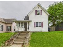 Charming two-story home with a front yard and concrete steps leading to the entrance at 907 S A St, Elwood, IN 46036