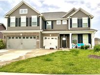 Charming two-story home with a manicured lawn, three-car garage, and inviting front porch at 9133 Thames Dr, Avon, IN 46123