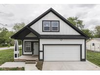 Charming two-story home with a white exterior, black trim, a garage, and a well-manicured front lawn at 9317 E 36Th Pl, Indianapolis, IN 46235