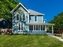 Charming two-story home with a welcoming front porch and beautifully maintained lawn at 1034 N Tacoma Ave, Indianapolis, IN 46201