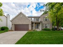 Charming two-story brick home with a well-manicured lawn, attached garage, and inviting front porch at 13271 Aquamarine Dr, Carmel, IN 46033