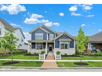 Charming two-story home with a brick walkway, manicured lawn, and a beautiful blue exterior at 1364 Chatham Hills Blvd, Westfield, IN 46074