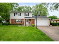 Charming two-story home with brick facade, white siding, attached garage, and well-maintained lawn at 1495 E 240 N, Anderson, IN 46012