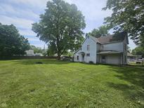 Spacious lawn and mature trees surround this quaint two-story home at 1706 Reverend J.T. Menifee St, Anderson, IN 46016