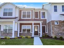 Inviting two-story townhome featuring a cozy front porch and stylish exterior elements at 19450 Northwest Dr, Westfield, IN 46074
