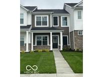 Charming two-story townhouse features a dark door, manicured lawn, and inviting facade at 19450 Northwest Dr, Westfield, IN 46074