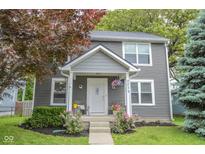 Charming two-story home with a well-maintained front yard and inviting entryway with chairs and decor at 2235 N Kenwood Ave, Indianapolis, IN 46208