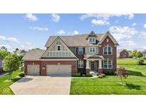 Beautiful two-story brick home featuring a three-car garage and manicured lawn at 2447 Stonehaven Dr, Avon, IN 46123
