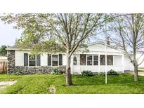 Charming single-story home with a stone facade and a welcoming front porch, surrounded by lush green landscaping at 315 Schoolhouse Rd, Franklin, IN 46131