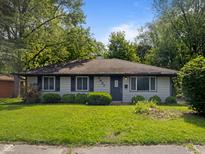 Charming single-story home featuring gray siding, dark shutters, and a lush green lawn at 3627 N Brentwood Ave, Indianapolis, IN 46235