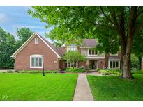 Traditional brick home with a lush front yard and mature trees, offering classic curb appeal at 5073 St Charles Pl, Carmel, IN 46033