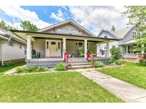 Charming home with a welcoming front porch, well-maintained lawn, and red railing, blending character and curb appeal at 518 N Emerson Ave, Indianapolis, IN 46219