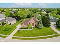 A well-maintained two-story brick home with a landscaped front yard and a long concrete driveway at 5251 Apache Moon, Carmel, IN 46033