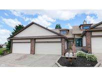 Charming townhome featuring attached two-car garage and a welcoming front entrance with landscaped flower beds at 608 Cielo Vista Dr, Greenwood, IN 46143