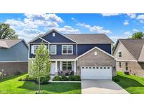 Charming two-story home featuring a brick facade, well-manicured lawn, and attached two-car garage at 7319 Farlin Dr, Whitestown, IN 46075