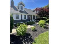 Charming home featuring dark siding, white shutters, and lush landscaping at 8655 Chateaugay Dr, Indianapolis, IN 46217