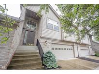 Charming townhome exterior with brick accents, attached garage, and landscaped front yard at 9117 Thoreau Ct, Fishers, IN 46037