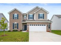 Charming two-story home with brick and vinyl siding, blue shutters, a manicured lawn, and a two car garage at 1065 Bent Branch Ln, Greenwood, IN 46143