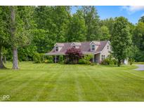 Charming home with a sprawling lawn and lush landscaping on a sunny day at 12383 S 25 W, Columbus, IN 47201