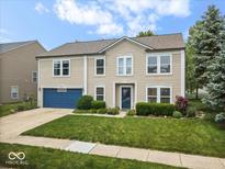 Charming two-story home featuring a blue garage door, well-maintained lawn, and manicured landscaping at 12624 Majestic Way, Fishers, IN 46037