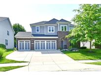 Beautiful two-story home with a three car garage, brick accents, and manicured lawn at 18726 Tillamook E Run, Noblesville, IN 46062
