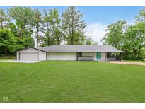 Charming single-story home with a well-maintained lawn and a bright turquoise front door at 233 N Devon Ave, Indianapolis, IN 46219