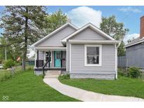Charming home with a well-maintained lawn and a bright turquoise front door at 2531 E Brookside Ave, Indianapolis, IN 46218