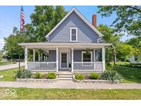 Charming home featuring a cozy front porch with white railings and manicured landscaping at 301 S Main St, Whitestown, IN 46075
