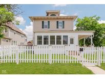 Charming two-story home featuring a white picket fence and well-maintained lawn at 3035 N Capitol Ave, Indianapolis, IN 46208