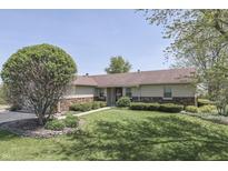 Charming single-story home with a lush green lawn and mature trees at 407 N Matthews Rd, Greenwood, IN 46143