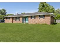 Charming brick home with a well-maintained lawn, black shutters, and a cheerful blue front door at 4126 S Gerrard Dr, Indianapolis, IN 46221
