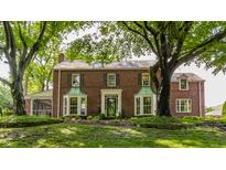 Charming brick home with meticulously landscaped front yard and mature trees at 5165 E Pleasant Run Pkwy S Dr, Indianapolis, IN 46219