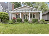 Charming home with a covered front porch, inviting curb appeal and manicured landscaping at 5259 Broadway St, Indianapolis, IN 46220