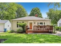 Charming bungalow-style home featuring a cozy front deck, well-maintained lawn, and colorful flower planters at 5333 Ralston Ave, Indianapolis, IN 46220
