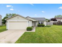 Charming single-story home featuring an attached two-car garage and a well-maintained lawn with manicured shrubs at 560 Tracy Ln, Brownsburg, IN 46112