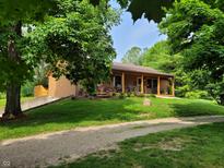 Charming home with a covered front porch and nicely landscaped yard, perfect for relaxing at 5730 S 50 W, Trafalgar, IN 46181