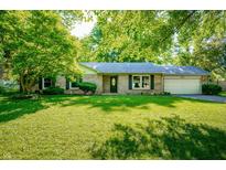 Charming single-story home with a well-maintained lawn and mature trees providing shade at 5873 N Victoria Dr, Indianapolis, IN 46228