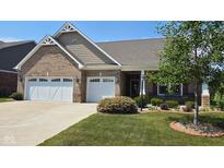 Charming brick home featuring a three-car garage and well-manicured front yard at 6184 Farlin Dr, Whitestown, IN 46075