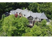 Expansive estate-style home with beautiful landscaping and mature trees, offering privacy and charm from every angle at 6412 Fall Creek Rd, Indianapolis, IN 46220