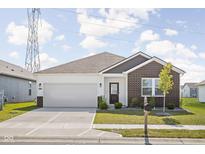 Charming single-story home with brick accents, a well-manicured lawn, and a two-car garage at 7431 Stillness Dr, Indianapolis, IN 46268