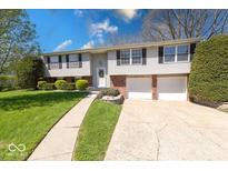 Charming two-story home with a well-maintained lawn and attached two-car garage at 8120 Trevellian Way, Indianapolis, IN 46217