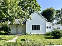 Charming home featuring a light-colored exterior, well-maintained lawn, and mature trees at 901 Columbia Ave, Alexandria, IN 46001