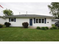 Charming single-story home featuring white siding, blue shutters and door, and a well-maintained lawn at 1021 Harney Dr, Lebanon, IN 46052