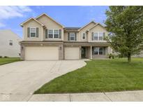 Inviting two-story home with a well-manicured lawn, three-car garage, and classic curb appeal at 11531 Short Iron Ln, Indianapolis, IN 46235