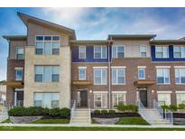 Modern townhouse featuring a combination of brick and stone facade, complemented by well-manicured landscaping at 13050 Grand Vue Dr, Carmel, IN 46032