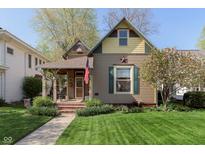 Charming home featuring a covered porch, well-manicured lawn, and an American flag display at 1352 Clinton St, Noblesville, IN 46060