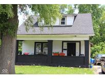 Charming home with a cozy front porch, black brick accents, and a welcoming entrance at 1619 Kessler Blvd E Dr, Indianapolis, IN 46220