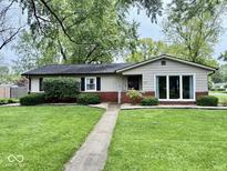 Charming single-story home with a well-manicured lawn and landscaped garden beds at 1917 W Norwood Dr, Muncie, IN 47304