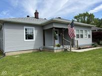Charming home featuring an inviting front porch, gray siding, and an American flag at 233 N 16Th Ave, Beech Grove, IN 46107