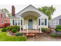 Charming home featuring a brick front porch with white Adirondack chairs and a light blue front door at 28 N Elizabeth St, Indianapolis, IN 46219